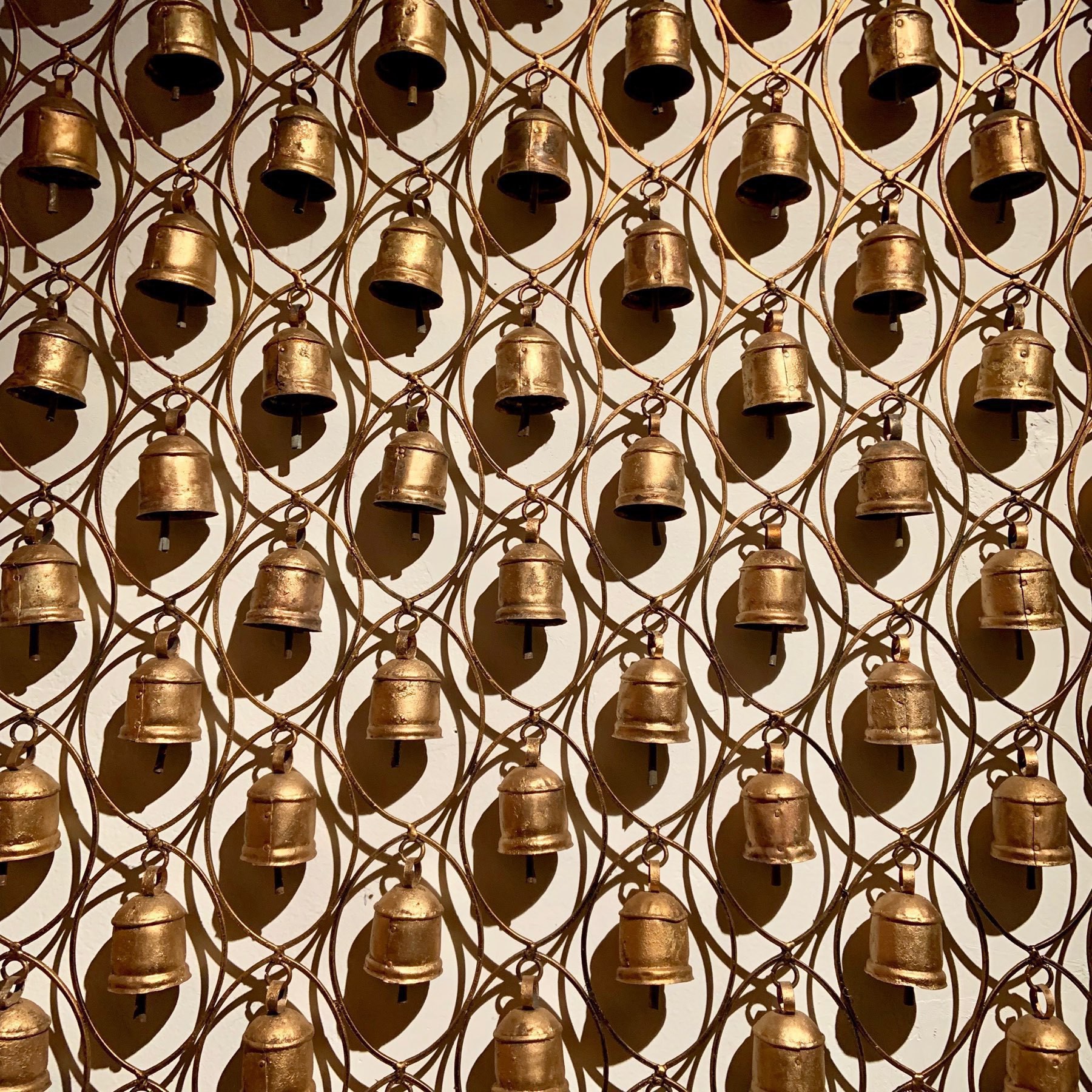 many bells hanging from a frame